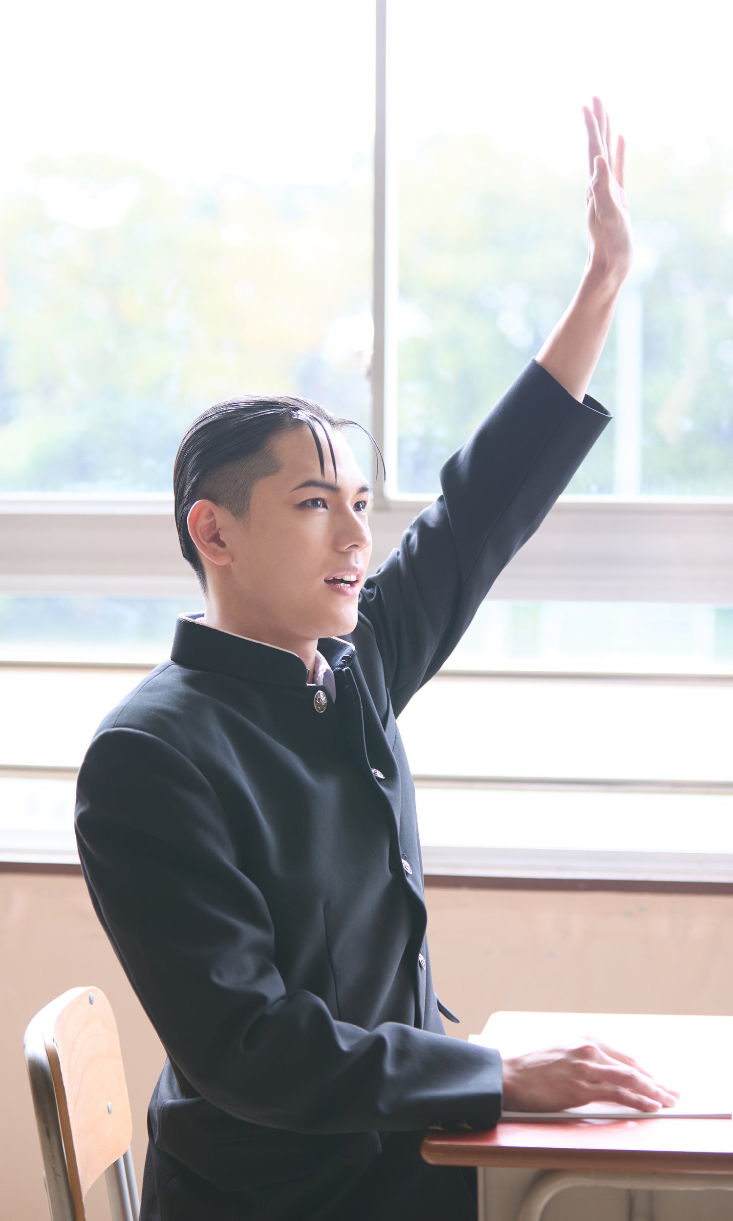 教室で手を挙げる姿を写した公式掲載カット